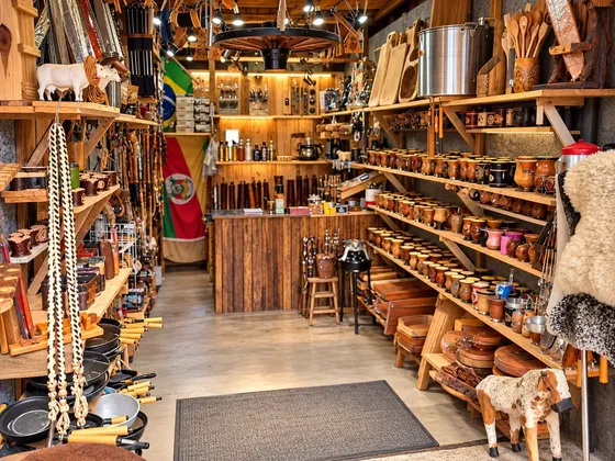 Interior da loja com prateleiras de cuias, utensílios e artigos campeiros