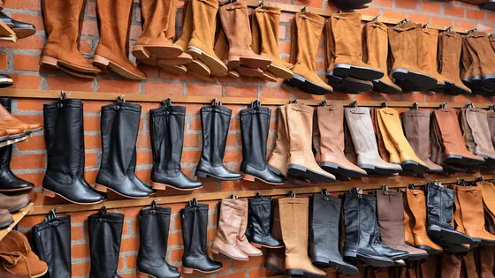 Parede da loja com várias botas de couro expostas